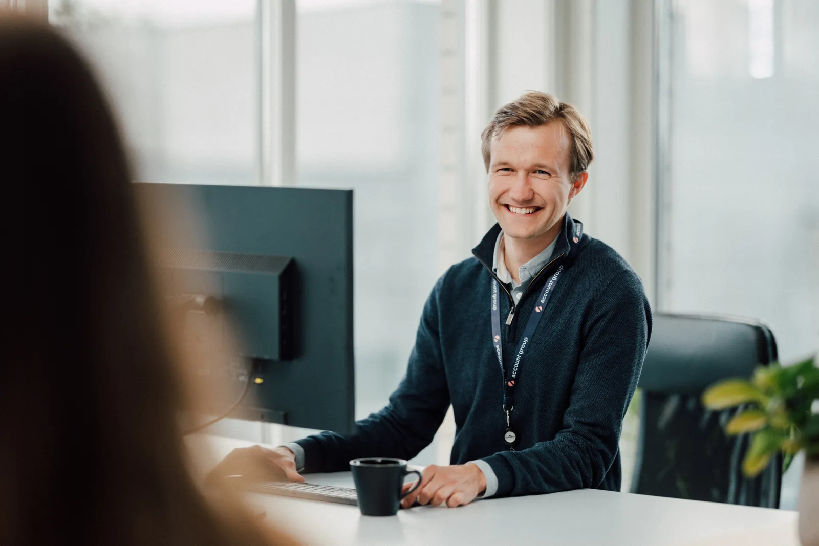 Kollega i samtale ved pulten hos Account Group