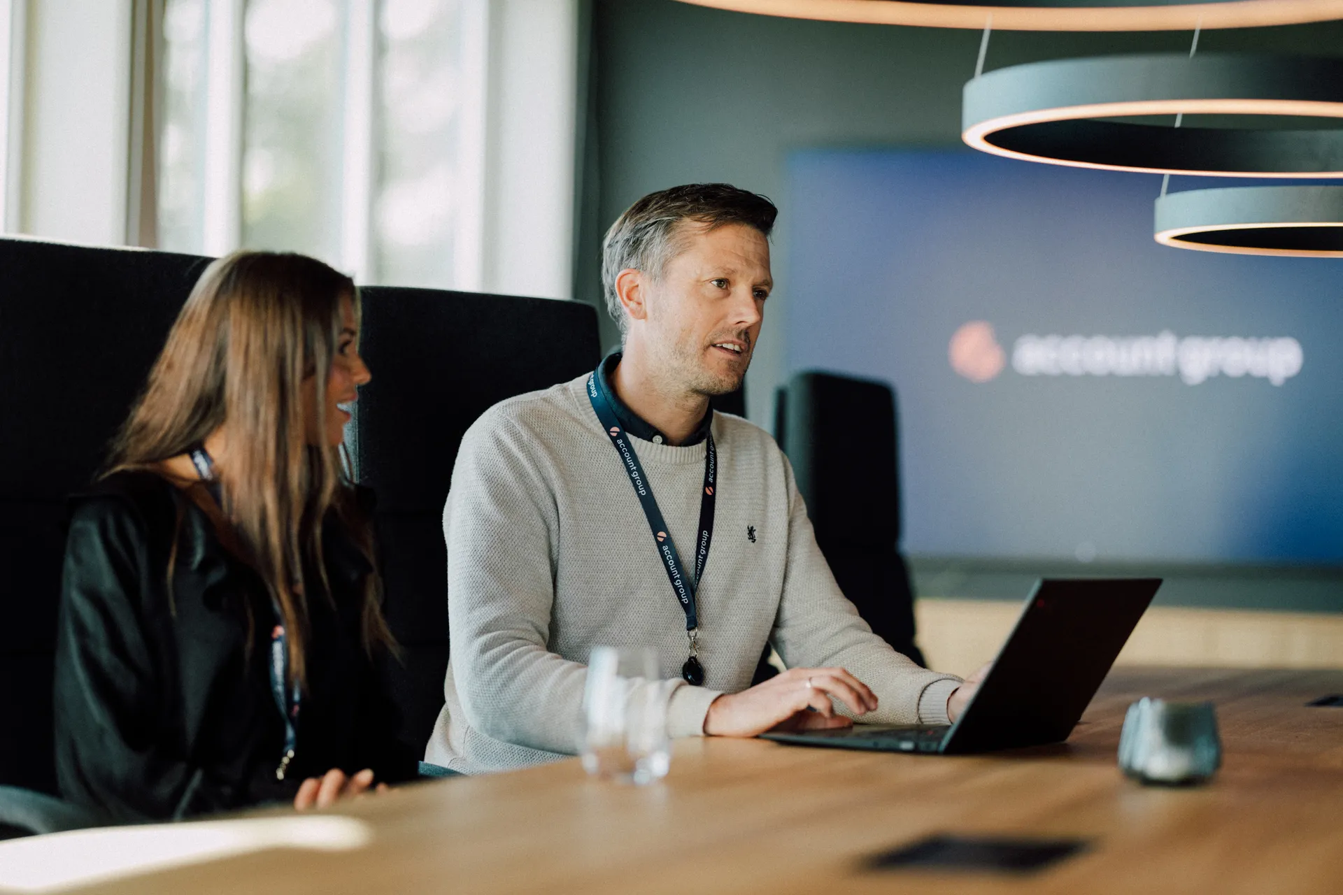 To rådgivere i samtale ved laptop hos Account Group